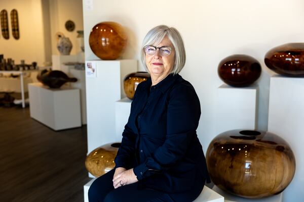 Owner Carr McCuiston poses with several Moulthrop vessels for a portrait at Signature Contemporary Craft Gallery in Atlanta on Tuesday, December 3, 2024. The gallery is closing after 62 years. (Arvin Temkar / AJC)