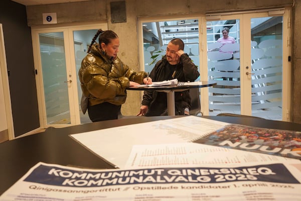 A woman votes during an early voting for Greenlandic parliamentary elections at the city hall in Nuuk, Greenland, Monday, March 10, 2025. (AP Photo/Evgeniy Maloletka)