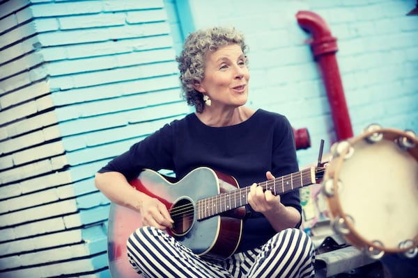 Elise Witt joins a group of buskers in Little Five Points to strum a tune. CONTRIBUTED BY JESSICA LILY