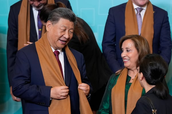 China's President Xi Jinping, left, speaks with Peru's President Dina Boluarte, right, as they and other APEC leaders gather for a family photograph at the APEC Summit in Lima, Peru on Saturday, Nov. 16, 2024. (AP Photo/Manuel Balce Ceneta)