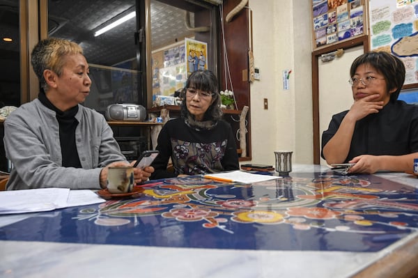 Kyoko Yamaguchi, left, Fumie Kano, center, and Takako Ueno, who oppose the presence of the Japan Self-Defense Forces (JSDF) base on Yonaguni island, gather for an interview with the AP at Kano's inn in Yonaguni, a tiny island on Japan's western frontier, Friday, Feb. 14, 2025. (AP Photo/Ayaka McGill)