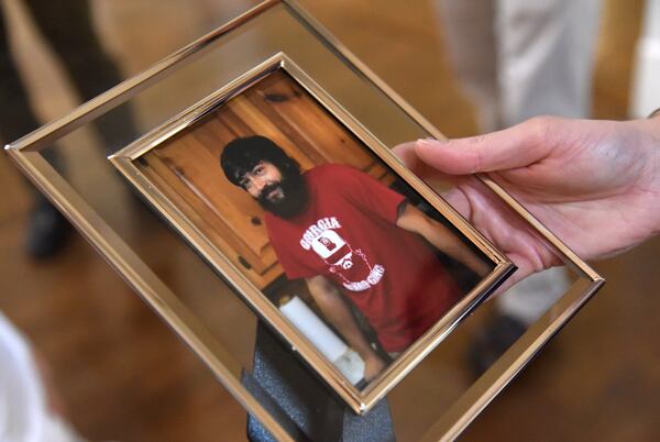 July 25, 2018 Alpharetta - Julie Ivey holds a photograph of her brother Gregg Ivey, who died of a heroin overdose, at Little River Farms on Wednesday, July 25, 2018. Gregg Ivey who loved music and his dog River passed out, stopped breathing and soon died at North Fulton Hospital of an overdose. His friend, Graham Williams, who injected the drug into Ivey’s vein, has been charged with felony murder, with the underlying felony being distribution of heroin. HYOSUB SHIN / HSHIN@AJC.COM