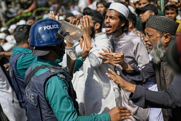 Policemen stop members and supporters of the banned Islamist group Hizbut Tahrir during a march near Baitul Mokarram Mosque in Dhaka, Bangladesh, Friday, March 7, 2025. (AP Photo/Mahmud Hossain Opu)