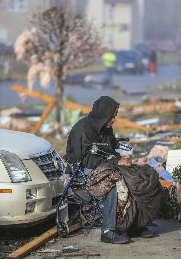 Daniel White Sr. rests in his driveway surrounded by storm debris on Jumpers Trail a day after the storm. JOHN SPINK/JSPINK@AJC.COM