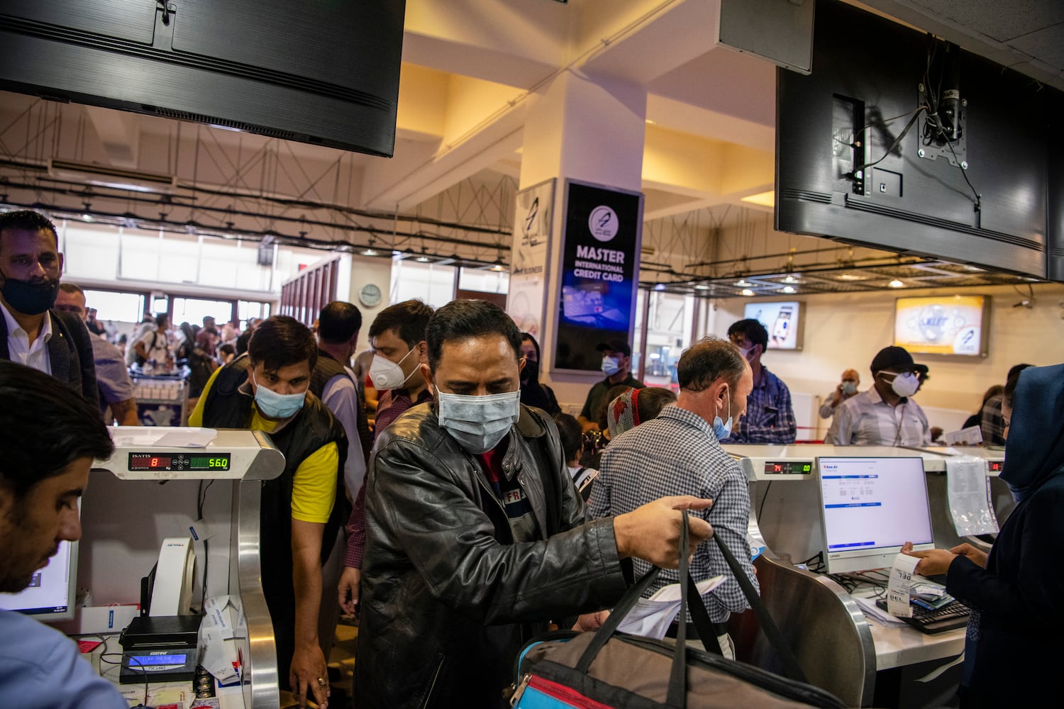 Afghans and travelers pass through checkpoints at the Hamid Karzai International Airport in Kabul, Afghanistan ahead of the TalibanÕs arrival, Aug. 15, 2021. (Jim Huylebroek/The New York Times)