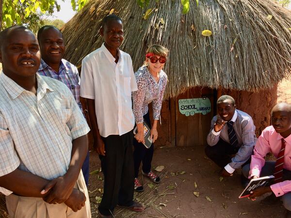 Barbara Mayfield poses in front of a tiny library in the hills above Lake Kariba. Courtesy of Claude and Barbara Mayfield