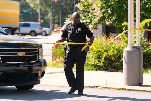 DeKalb police handle crime scene tape after a man was shot in front of a Goodwill hiring center.