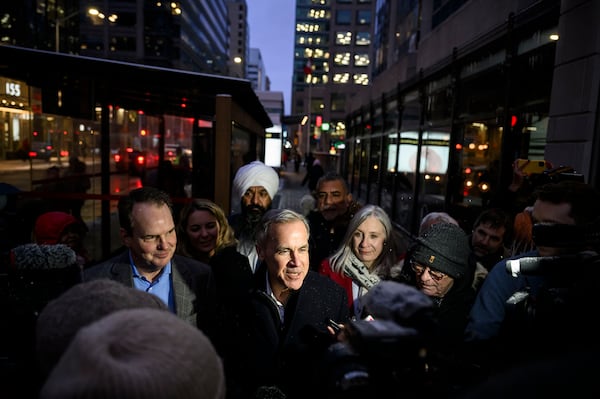 FILE - Mark Carney, candidate for the leadership of the Liberal Party of Canada, is surrounded by journalists outside a campaign event in Ottawa, Ontario, Jan. 23, 2025. (Justin Tang/The Canadian Press via AP, File) /The Canadian Press via AP)