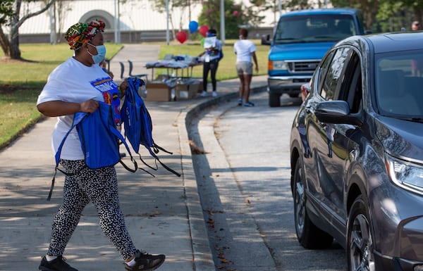 Teacher Trava Davis hands out free backpacks and other schools supplies at Kemp Elementary in Hampton, Georgia on August 8, 2020.  STEVE SCHAEFER FOR THE ATLANTA JOURNAL-CONSTITUTION