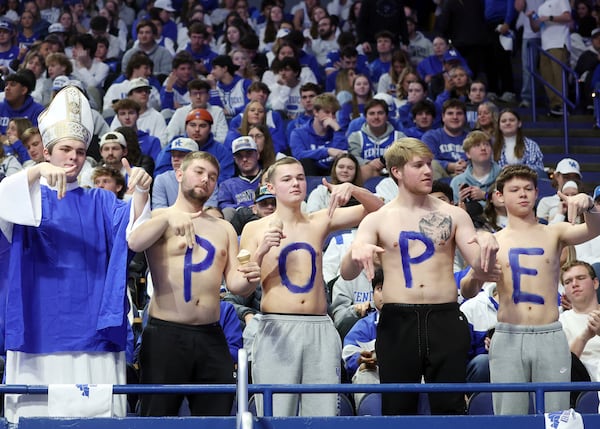 Kentucky students give L's down before an NCAA college basketball game against Louisville in Lexington, Ky., Saturday, Dec. 14, 2024. The Pope referred to is Kentucky head coach Mark Pope. (AP Photo/James Crisp)