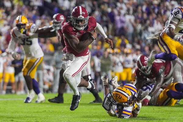 Alabama quarterback Jalen Milroe (4) breaks free from LSU safety Jardin Gilbert (2) on a touchdown carry in the second half an NCAA college football game in Baton Rouge, La., Saturday, Nov. 9, 2024. (AP Photo/Gerald Herbert)