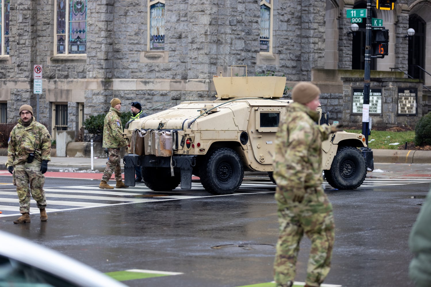 Soldiers direct traffic on a street near where people wait to enter a Trump rally at Capital One Arena in Washington, D.C. on Sunday, January 19, 2025, one day before Donald Trump’s inauguration. (Arvin Temkar / AJC)