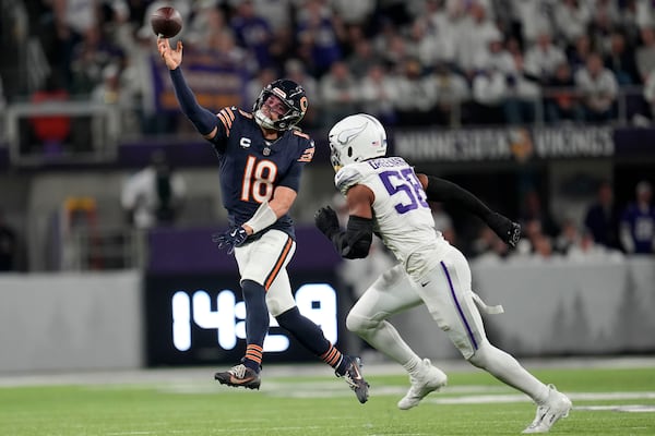 Chicago Bears quarterback Caleb Williams (18) throws a pass over Minnesota Vikings linebacker Jonathan Greenard (58) during the second half of an NFL football game, Monday, Dec. 16, 2024, in Minneapolis. (AP Photo/Abbie Parr)