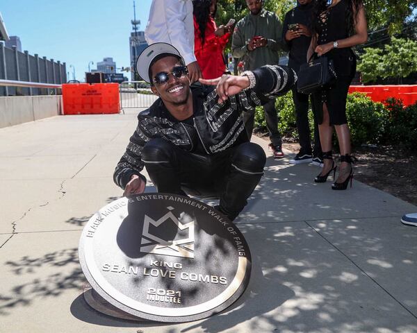 Christian Combs, son of Sean Combs, poses with his father's plaque on the Black Music and Entertainment Walk of Fame in downtown Atlanta.