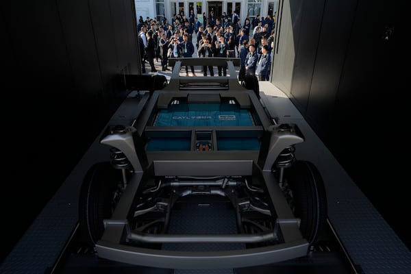 Attendees look at the next generation battery swapping station from China-based CATL, the world's largest maker of batteries for electric vehicles, before a launch presentation held in Xiamen, southern China's Fujian province on Wednesday, Dec. 18, 2024. (AP Photo/Ng Han Guan)