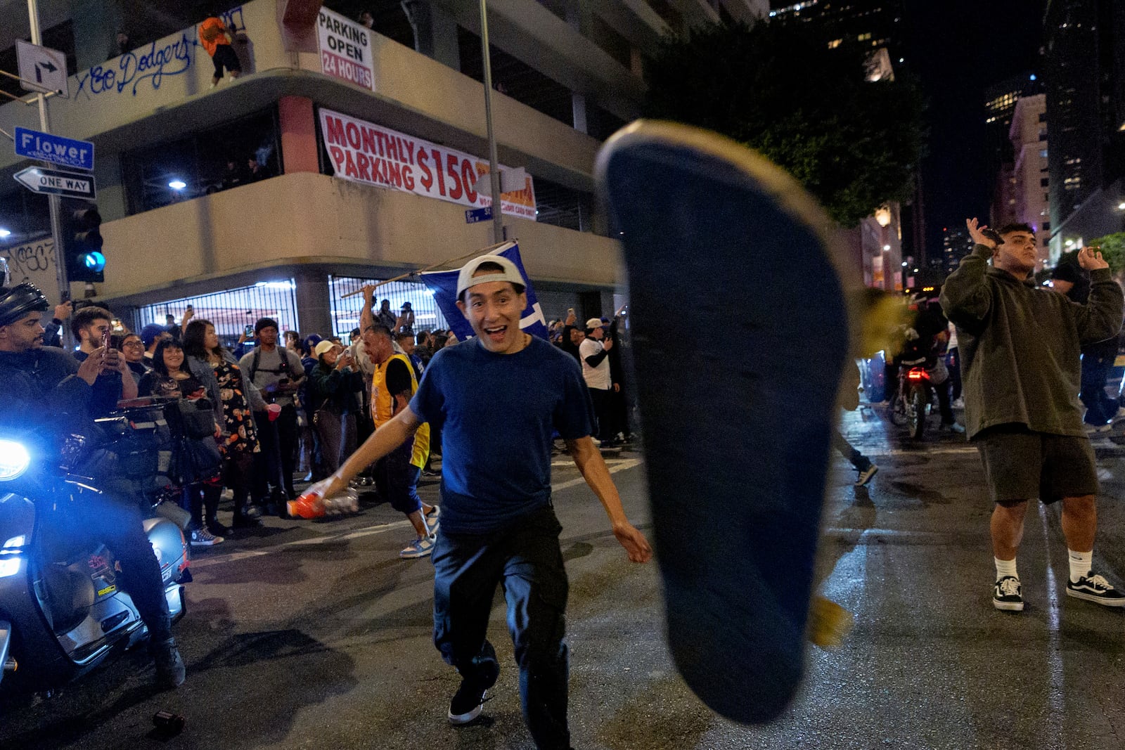 A fan looses control of his skateboard as fans celebrate on the streets after the Los Angeles Dodgers won against the New York Yankees in the baseball World Series Wednesday, Oct. 30, 2024, in Los Angeles. (AP Photo/Damian Dovarganes)