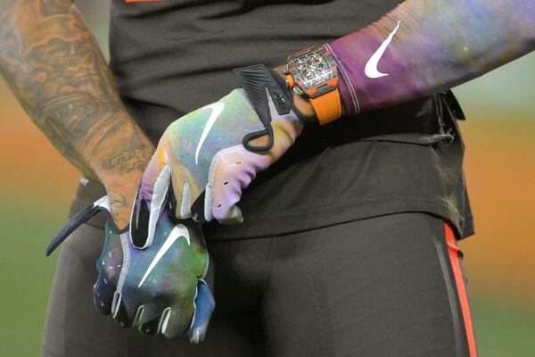 In this Sept. 22, 2019 file photo Nike logos adorn the gloves of Cleveland Browns wide receiver Odell Beckham Jr. (13) before an NFL football game against the Los Angeles Rams in Cleveland. Nike, the NFL and other businesses are giving their employees a paid day off on Juneteenth for the first time, the latest example of how American employers are responding to protests that have placed additional attention on racial injustice in the U.S. NFL Commissioner Roger Goodell wrote in a note Friday, June 12, 2020 that its offices would be closed June 19. (AP Photo/David Richard, file)