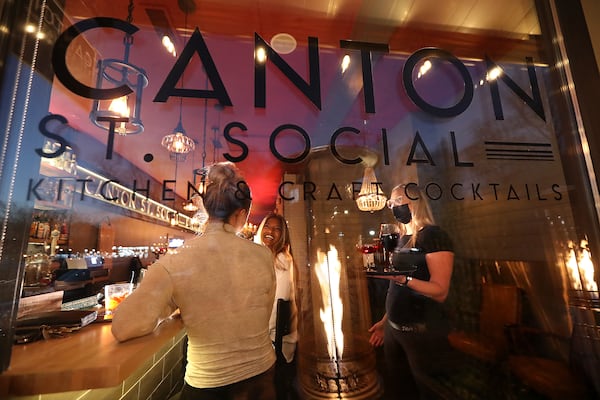 Manager Lillie Parnell (right) serves cocktails to Alexa Robertson (left) and Alicia Nachtali at the Canton St. Social kitchen & craft cocktail earlier this month, in Roswell. Owner Meredith Longwith opened the business last August figuring the health crisis would last only a few more months but has considered closing permanently as the pandemic continues. After seeing increased reservation bookings over the last several weeks she has some optimism about the future, but is still operating in the negative.  “Curtis Compton / Curtis.Compton@ajc.com”