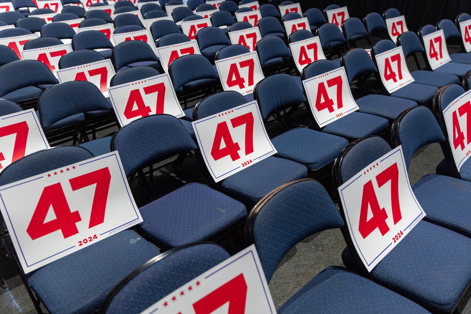 Placards are placed on seats before Republican presidential candidate Donald Trump’s rally at Gas South Arena in Duluth on Wednesday, October 23, 2024. (Arvin Temkar / AJC)