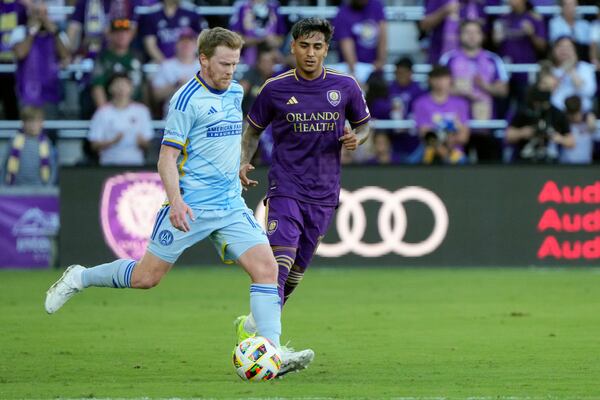 Atlanta United's Dax McCarty, left, moves the ball past Orlando City's Facundo Torres during the first half of an MLS Semifinal Conference playoff soccer match, Sunday, Nov. 24, 2024, in Orlando, Fla. (AP Photo/John Raoux)