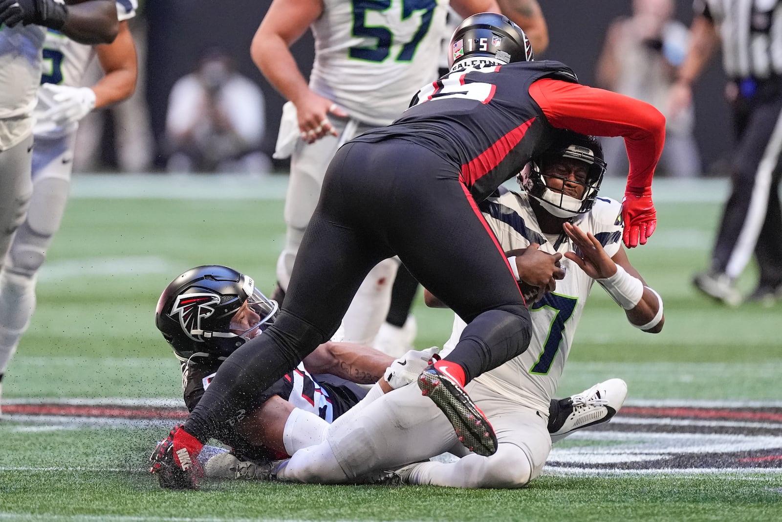 Seattle Seahawks quarterback Geno Smith (7) is stopped by Atlanta Falcons linebackers Kaden Elliss (55) and Matthew Judon (15)during the second half of an NFL football game, Sunday, Oct. 20, 2024, in Atlanta. (AP Photo/ Mike Stewart)