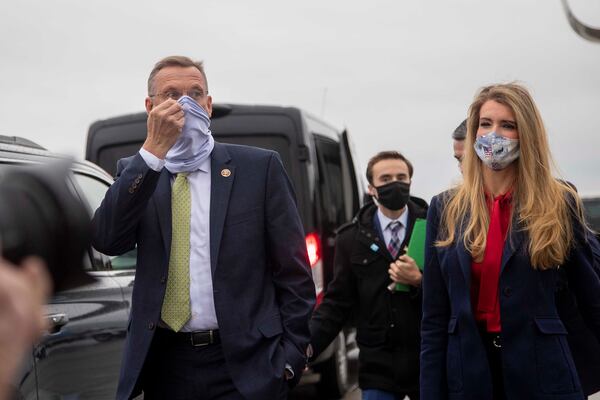 Doug Collins and Kelly Loeffler walk alongside each at Dobbins Air Reserve Base Friday, Dec. 4, 2020 in Marietta, Georgia.  (Alyssa Pointer/Atlanta Journal-Constitution/TNS) 