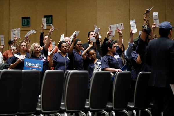 Casino workers hold up presidential preference cards as they support Democratic presidential candidate Bernie Sanders.