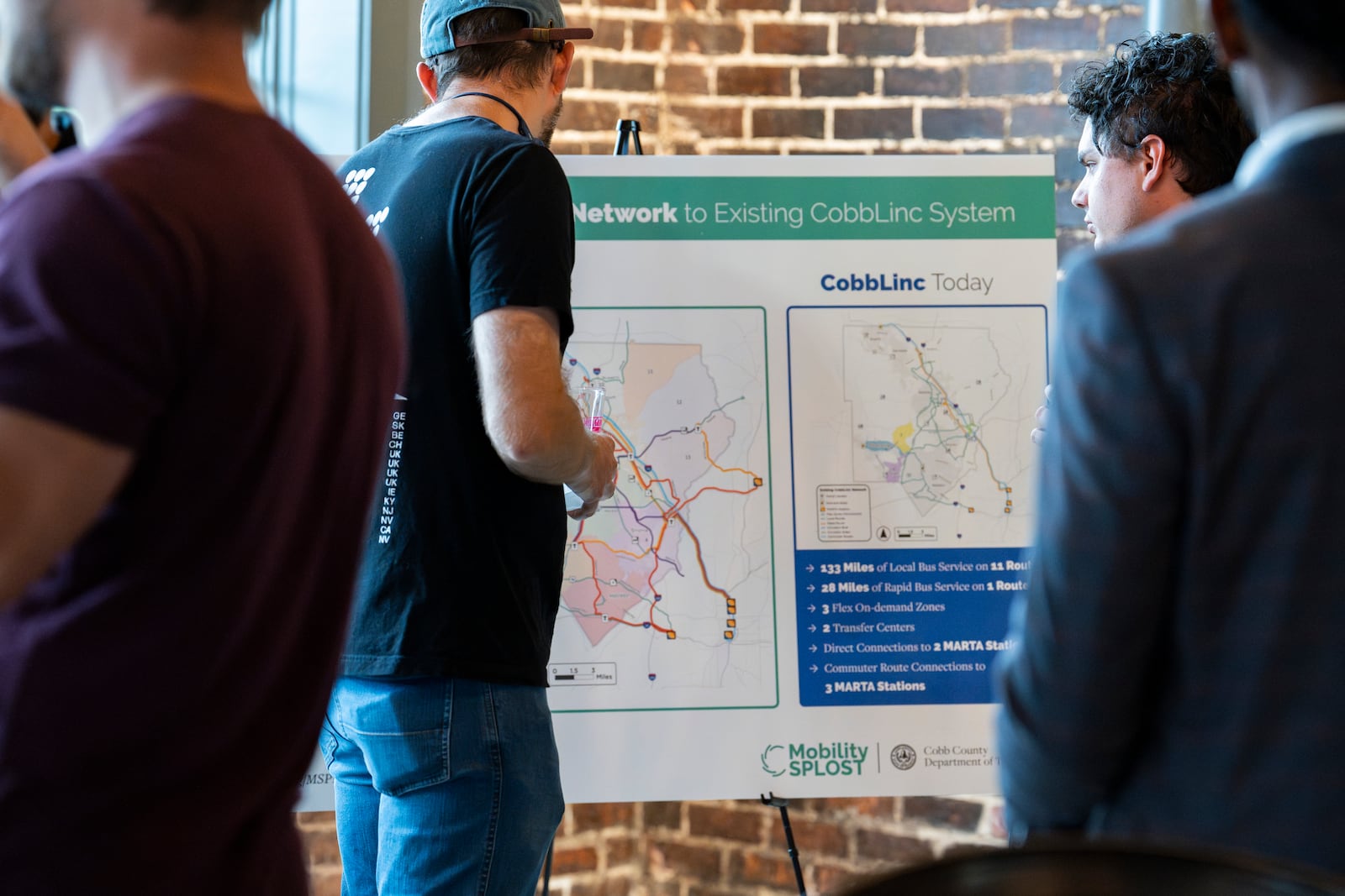 Attendees read promotional materials at a pro-transit campaign kickoff supporting the MSPLOST referendum in Cobb County on Wednesday, Sept. 18, 2024. (Olivia Bowdoin for The Atlanta Journal-Constitution)