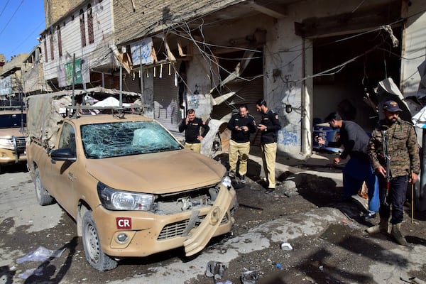 Security officials examine a damaged security forces' vehicle at the site of a bomb blast in Quetta, Pakistan, Friday, Feb. 28, 2025. (AP Photo/Arshad Butt)