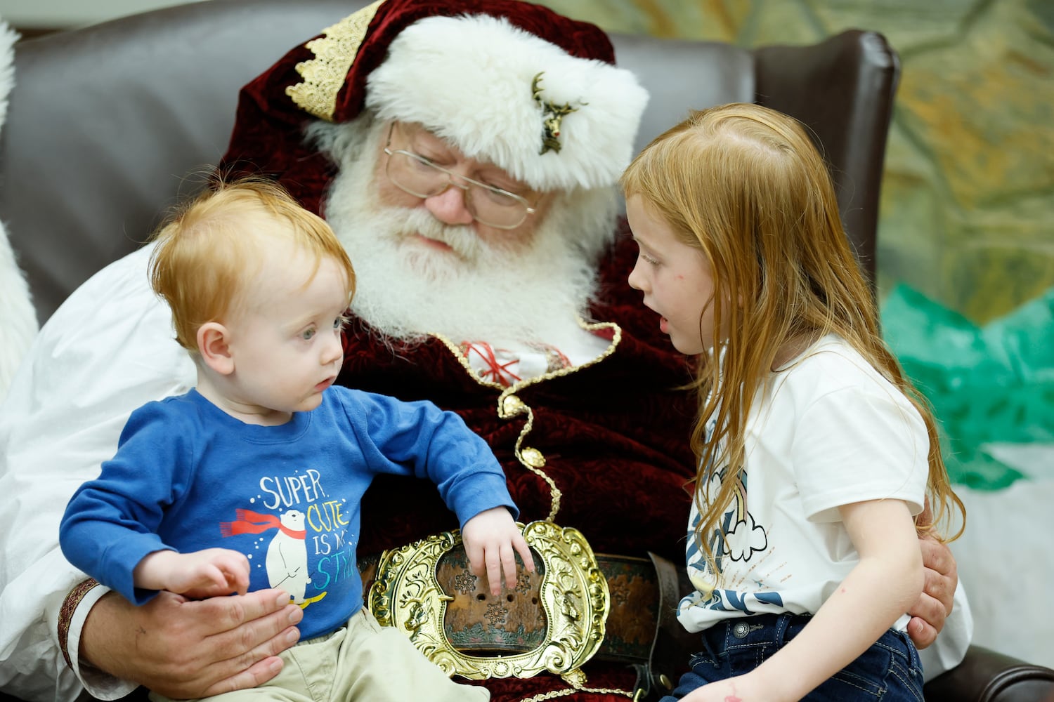 Woodrow "Willy" Smith, who plays Santa, interacts with Elijah and Ena Sells during the Christmas dinner that is free to all the residents and family members of Santa Claus.
 Miguel Martinez / miguel.martinezjimenez@ajc.com