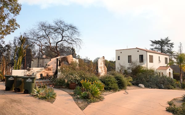 A home at left destroyed by the Eaton Fire stands next to an intact residence, Thursday, Jan. 9, 2025, in Altadena, Calif. (AP Photo/Chris Pizzello)