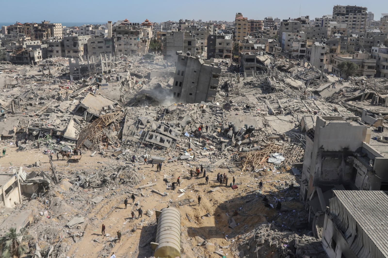 FILE - Palestinians walk through the destruction left by the Israeli air and ground offensive on the Gaza Strip near Shifa Hospital in Gaza City, on April 1, 2024. (AP Photo/Mohammed Hajjar, File)