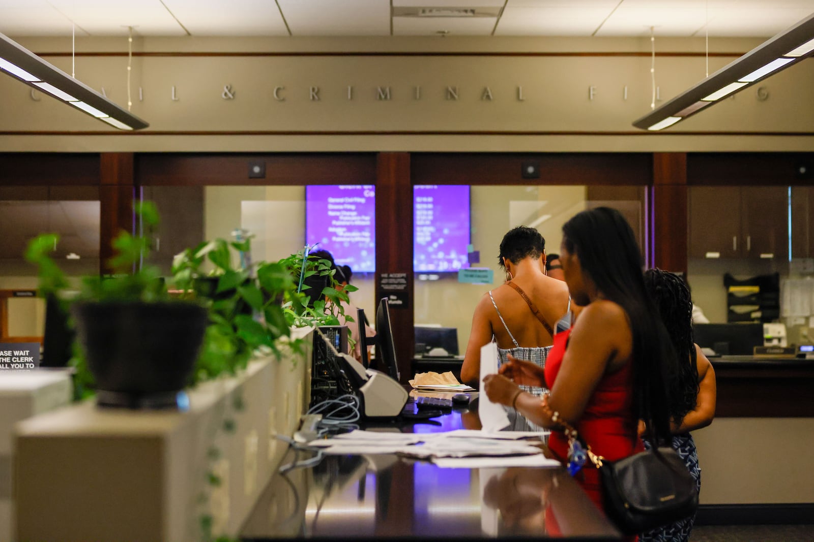 People are spotted completing administrative paperwork at the clerk’s office windows in the Cobb County Superior Court on Thursday, August 8. Chief Judge Gregory Poole issued a 30-day emergency order on Wednesday, suspending filing deadlines and other administrative requirements in civil and criminal cases.

(Miguel Martinez / AJC)