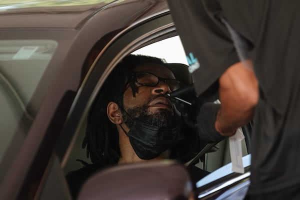 A man has a nasal swab taken at a Viral Solutions testing site in Brookhaven in August 2022. Metro Atlanta’s last Viral Solutions testing site for COVID-19 in Brookhaven, almost decided to close down. On a recent Friday however, patients were still driving up to get tested.  (Elijah Nouvelage for The Atlanta Journal-Constitution)