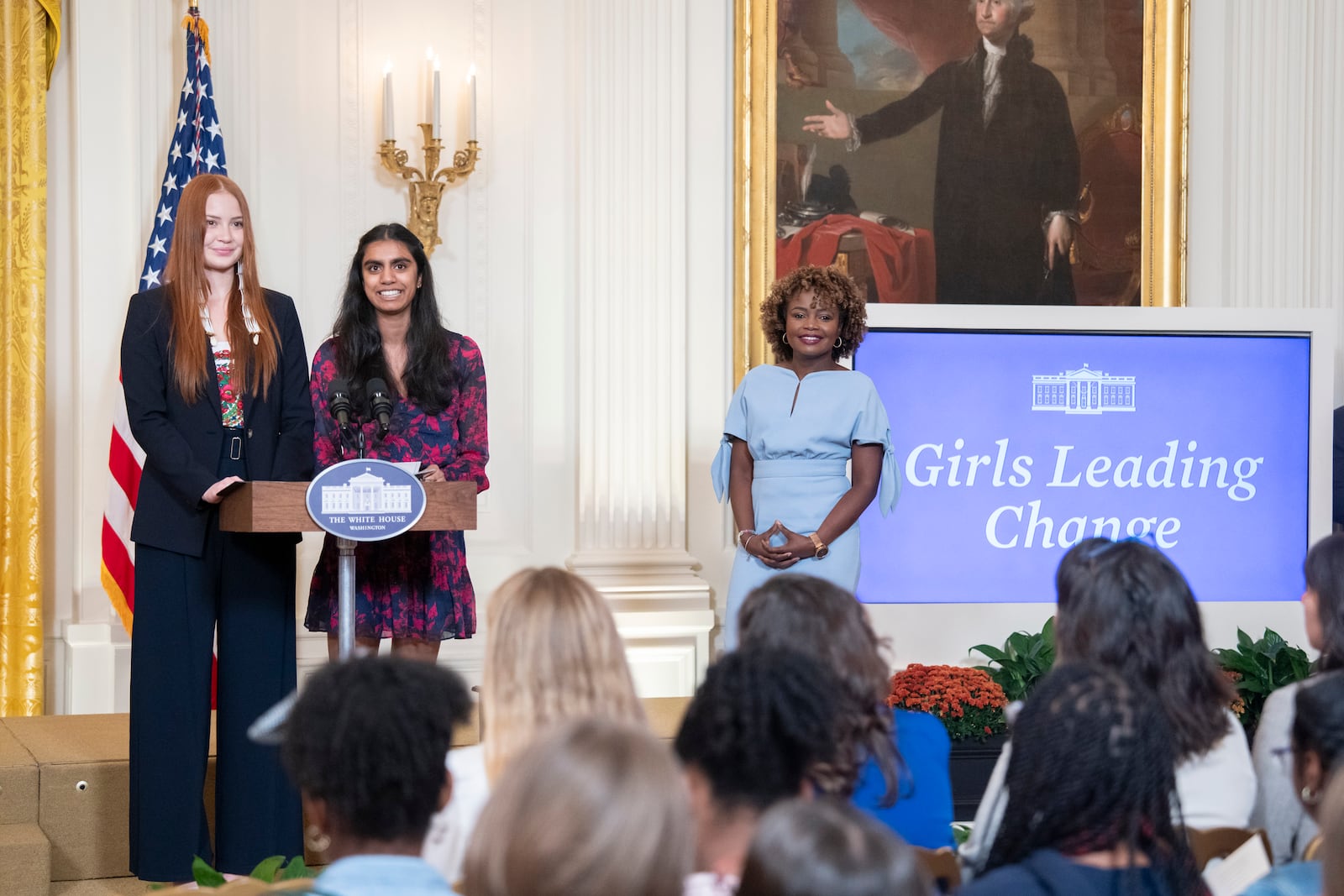 Pragathi Kasani-Akula, center, and Cheyenne Anderson introduce themselves at the 2024 "Girls Leading Change" event at the White House. Pragathi, 17, is a Forsyth County student who developed a new way to test for breast cancer. They appear on stage with White House Press Secretary Karine Jean-Pierre on Thursday, October 10, 2024, in the East Room of the White House. Official White House Photo by Erin Scott