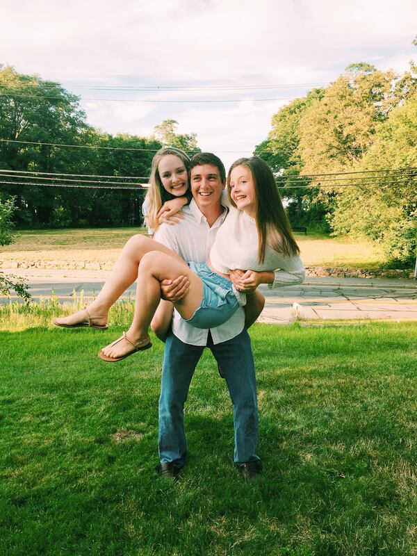 Stephen Norris holding his sister, Ali (11 at the time), with his other sister, Carolan, on his back at their beloved family home on Cape Cod during a family reunion.