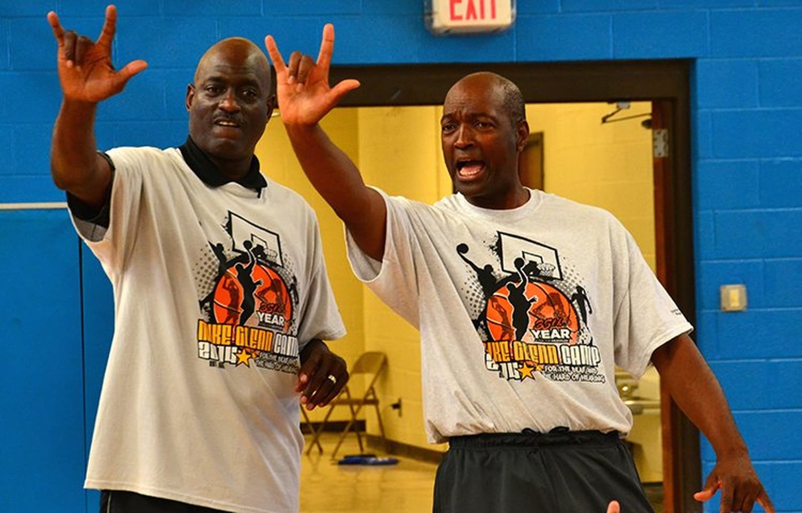 Mike Glenn (right) and volunteer Michael Cooper sign “I love you” to campers. CONTRIBUTED