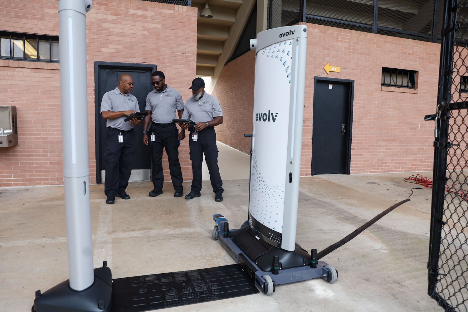 Analysts with the DeKalb County Safe Schools program perform a test run on the Evolv weapons detection system at Adams Stadium on Thursday, Aug. 15, 2024. The system has already been implemented in many DeKalb schools and will be expanding to football stadiums. (Natrice Miller/ AJC)