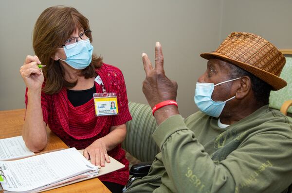 Social service director Sandi Thurber (left) chats with resident Robert Stanfield at Northside Gwinnett Extended Care Center in Lawrenceville. (Phil Skinner for The Atlanta Journal-Constitution)