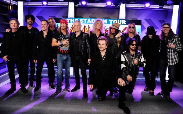 Musicians Rick Allen, from left, Tommy Lee, Vivian Campbell, Joe Elliott, Bret Michaels, Phil Collen, Rick Savage, Rikki Rockett (kneeling), C.C. DeVille, Nikki Sixx (kneeling), Vince Neil, Mick Mars and Bobby Dall announced "The Stadium Tour" in December 2019. (Photo by Chris Pizzello/Invision/AP)