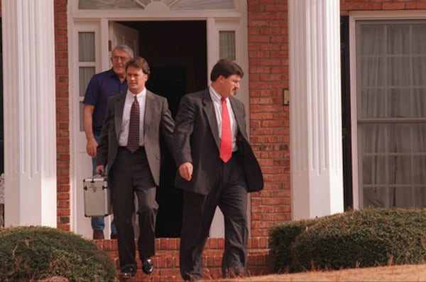 Boulder police investigator Steve Thomas exits the Roswell home of the grandparents of 6-year-old JonBenet Ramsey with a metal case of contents in January 1997 along with investigator Thomas Trougillo (right) and an unknown family member.