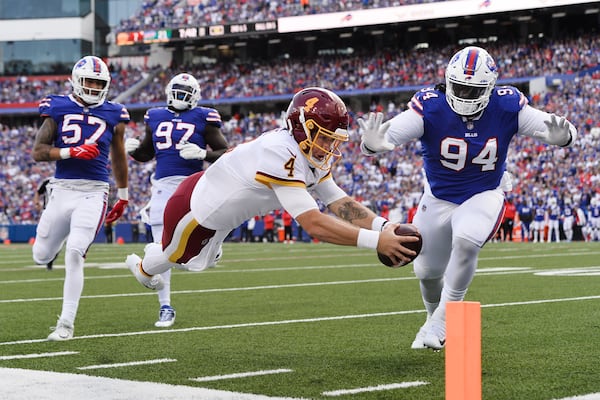 Washington quarterback Taylor Heinicke dives past Buffalo's Vernon Butler for a touchdown as the Bills' A.J. Epenesa (57) and Mario Addison (97) watch. In 2020, Epenesa was the rage until he ran a 5.04 in the 40-yard dash at the combine. He went 54th to Buffalo in the second round. (AP Photo/Adrian Kraus)