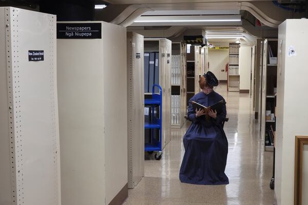 A tour guide at New Zealand's Parliament gives a spooky tour of the historical Parliament library, constructed in the late 19th century and rumored to be haunted, in Wellington, Thursday, March 20, 2025. (AP Photo/Charlotte Graham-McLay)