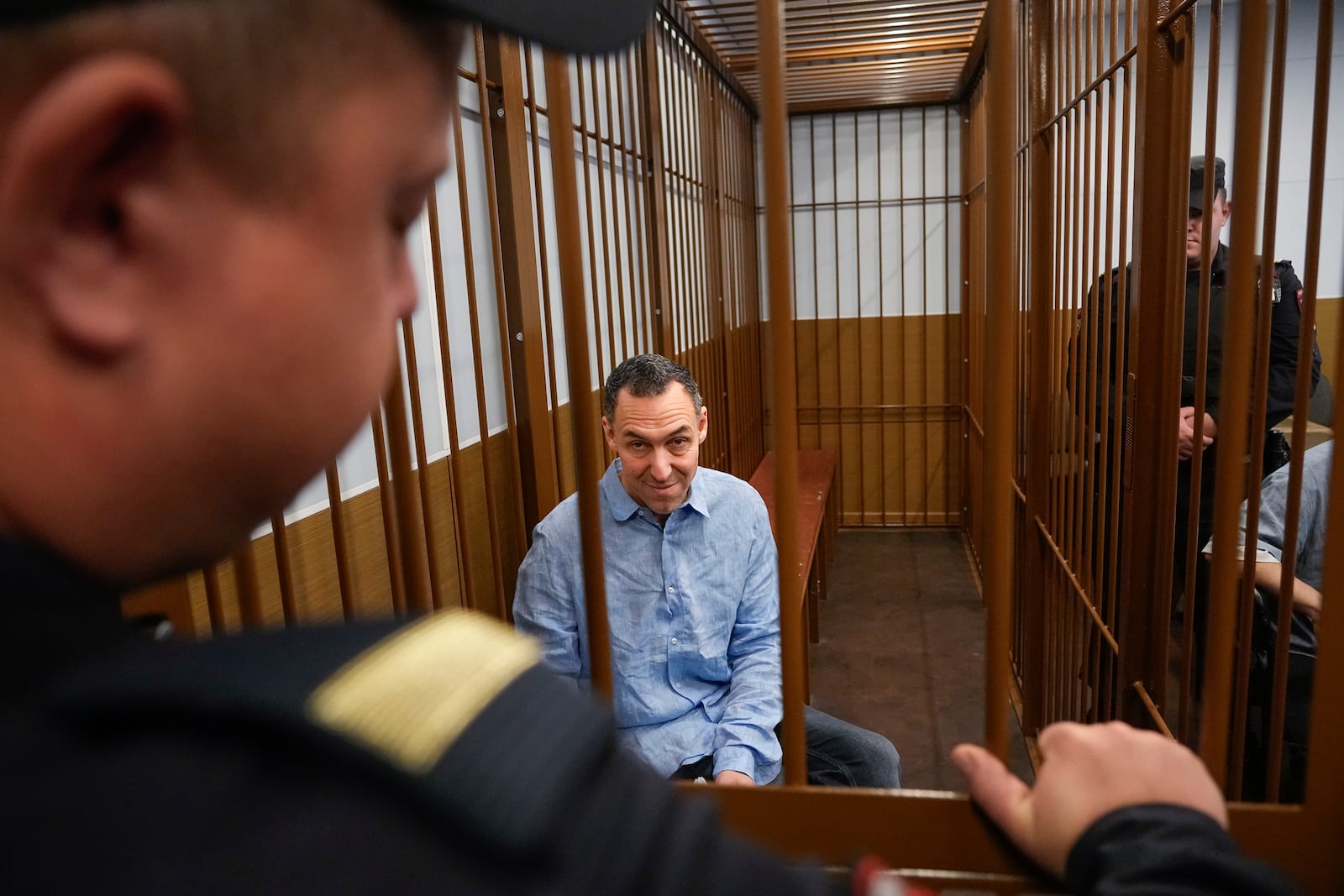 French citizen Laurent Vinatier sits in a cage prior to a court session at the Zamoskvoretsky District Court in Moscow, Russia, on Monday, Oct. 14, 2024. (AP Photo/Pavel Bednyakov)