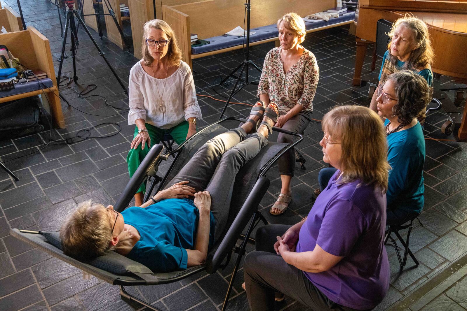 Voices of Love Threshold Choir members Susan Patterson (from left) Ann Lillya, Annamay Keeney, Shonali Banerjee and Jeanne Williams sing to Rose Watkins (in chair, acting as a patient) as they practice together at Emory Presbyterian Church in Decatur.  PHIL SKINNER FOR THE ATLANTA JOURNAL-CONSTITUTION