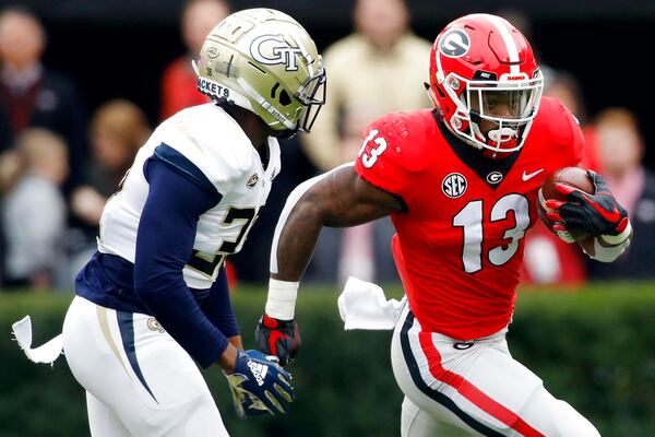 FILE - In this Saturday, Nov. 24, 2018, file photo, Georgia tailback Elijah Holyfield (13) drives past Georgia Tech defensive back Ajani Kerr (38) during the first half of an NCAA college football game in Athens Ga. No. 1 Alabama's typically tough defense will be challenged by No. 4 Georgia's offense that enters Saturday's SEC championship game on a roll. 