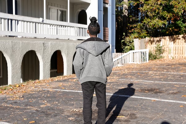 Stacie Jackson’s 10-year-old son, who she didn't want identified in this article, stands in the parking lot of their apartment complex in south Fulton County on Wednesday, Nov. 1, 2023. Their apartment, the only one she says she can afford, has been the site of more than 257 crimes including three homicides since they moved in a decade ago.