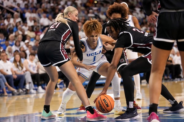 UCLA guard Kiki Rice (1) fights for the ball against South Carolina forwards Chloe Kitts (21) and Ashlyn Watkins (2) during the second half of an NCAA college basketball game, Sunday, Nov. 24, 2024, in Los Angeles. (AP Photo/Eric Thayer)