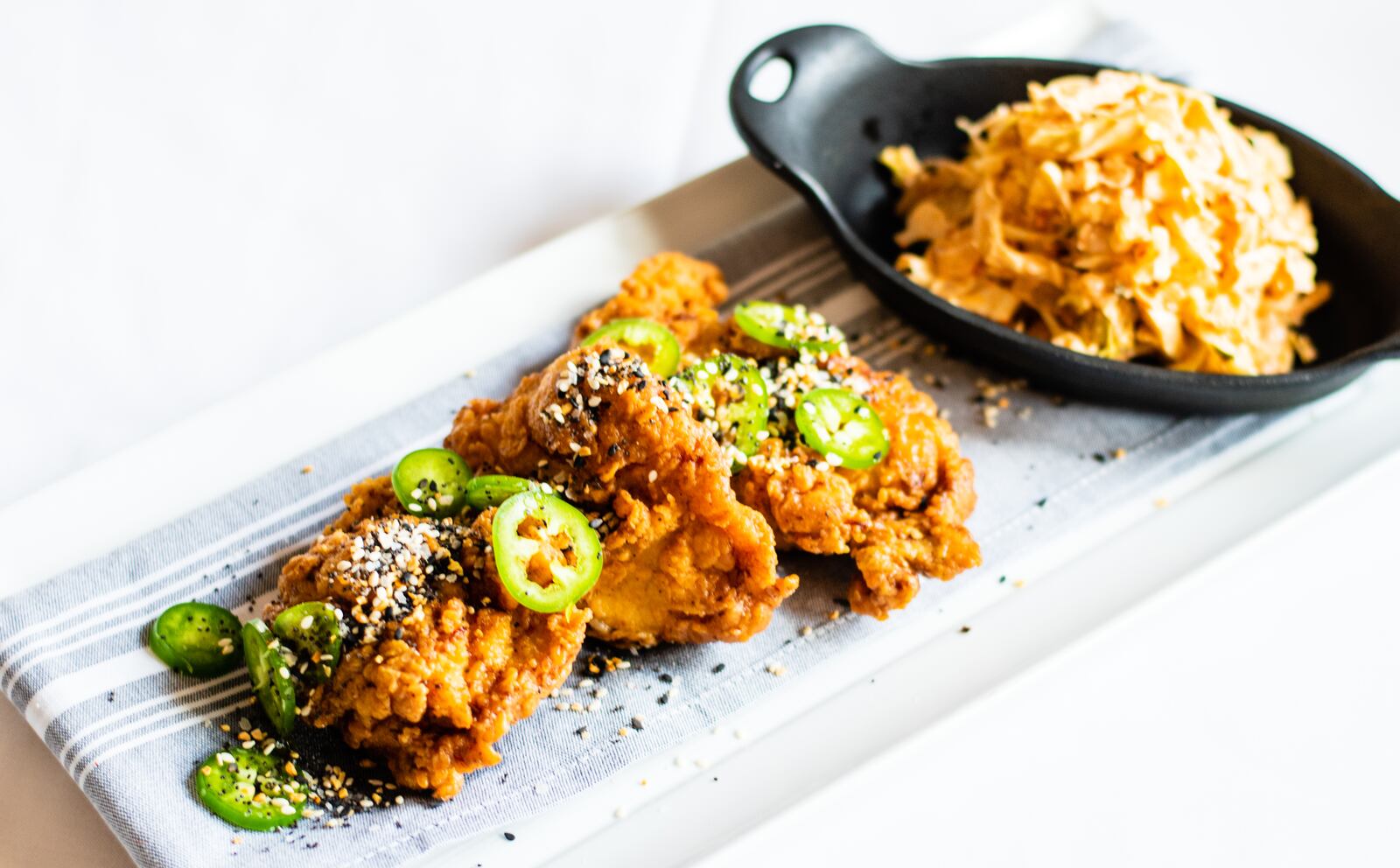 Boneless Pickle Fried Chicken Thighs with Hot Jalapeno Honey, shown with Kimchi Coleslaw, at Milton’s Cuisine and Cocktails in Alpharetta. CONTRIBUTED BY HENRI HOLLIS