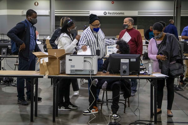 Fulton County Voter Registration Chief Ralph Jones (center) instructs a worker on how to use a ballot scanning machine during Fulton County's second recount of Presidential Election Day ballots at the Georgia World Congress Center, Tuesday, November 25, 2020. (Alyssa Pointer / Alyssa.Pointer@ajc.com)